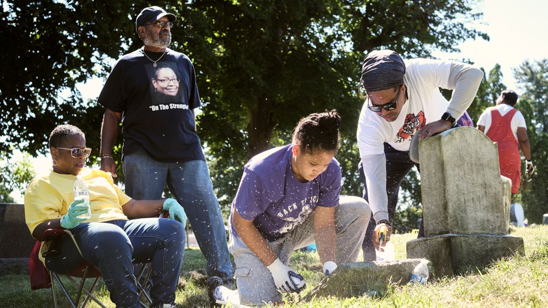 Mary Wright, Bill Armstrong, Amaya Pope and Dwayne Cowles Wright, from left, tidy family members' gravestones.