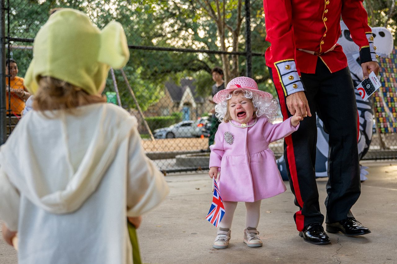 Madeline Evans begins to cry after winning a costume contest dressed as the late Queen Elizabeth II on Monday, October 31, in Houston, Texas.