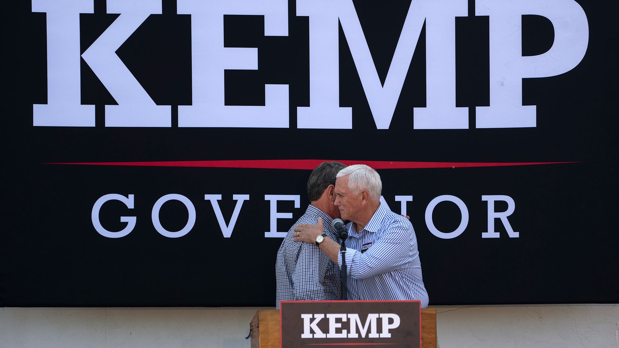 Former US Vice President Mike Pence embraces Georgia Gov. Brian Kemp during a campaign rally in Cumming, Georgia, on Tuesday, November 1.