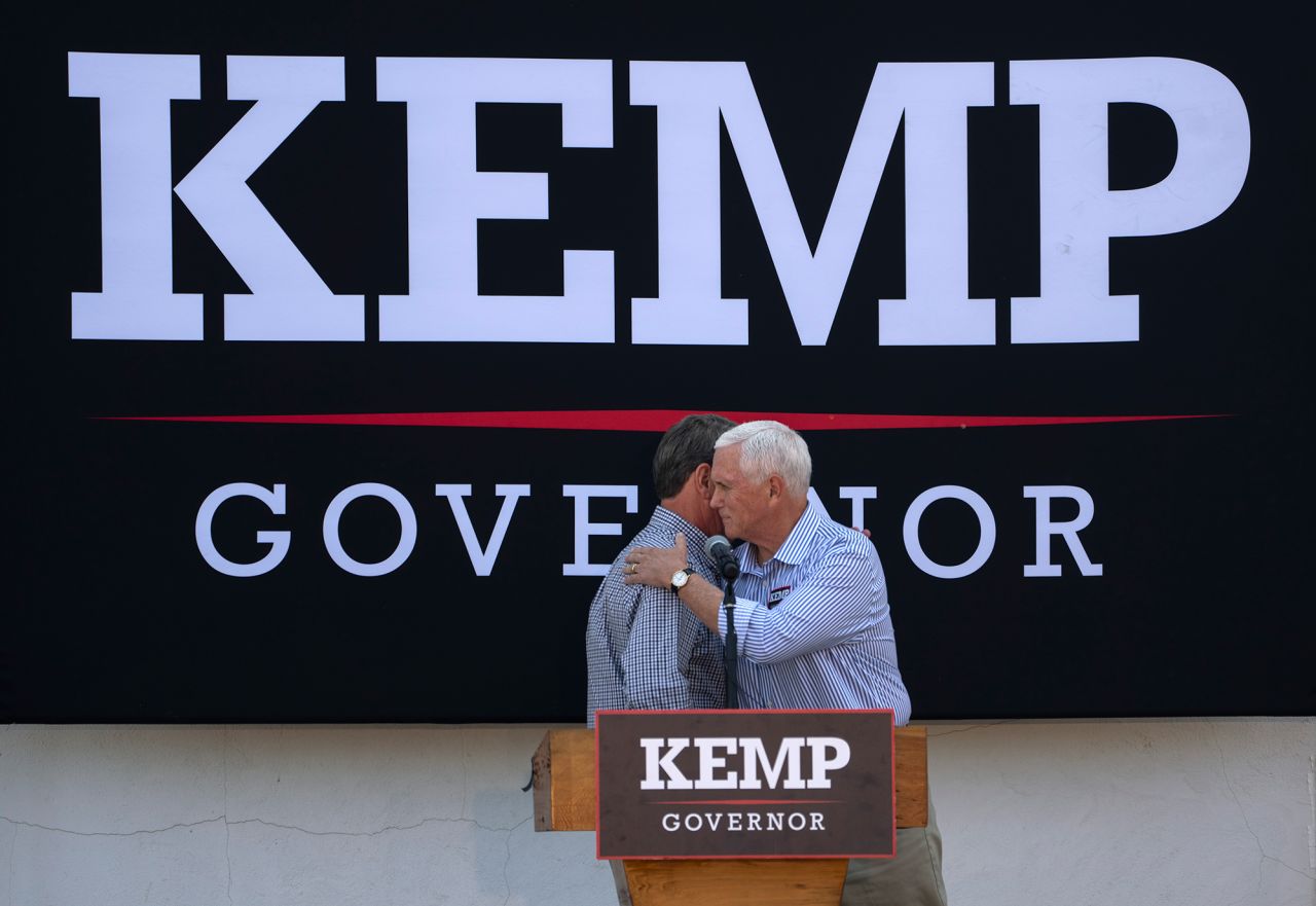 Former US Vice President Mike Pence embraces Georgia Gov. Brian Kemp during a campaign rally in Cumming, Georgia, on Tuesday, November 1.