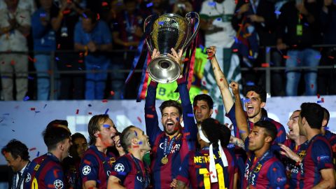 Piqué lifts the Champions League trophy after Barcelona won the competition in 2015.