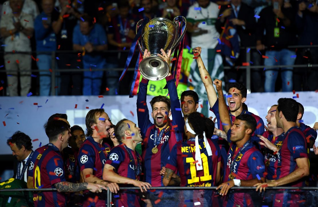 Piqué lifts the Champions League trophy after Barcelona won the competition in 2015.