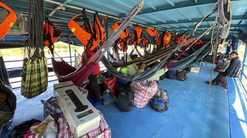 Foreign and Peruvian tourists wait in the boat where they have been detained at the Cuninico community in Loreto in the north of Peru, on November 4, 2022.