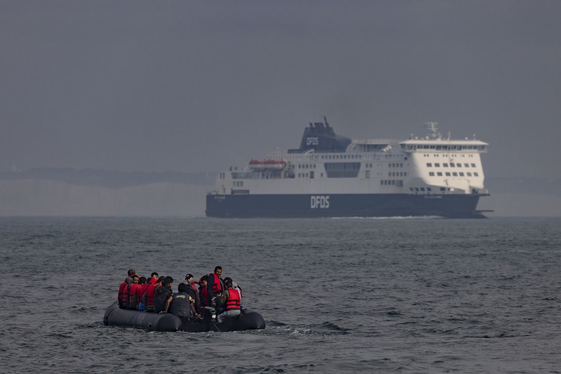 An inflatable craft carrying migrants crosses the shipping lane in the English Channel towards the white cliffs at Dover on August 4, 2022 off the coast of Dover, England. 