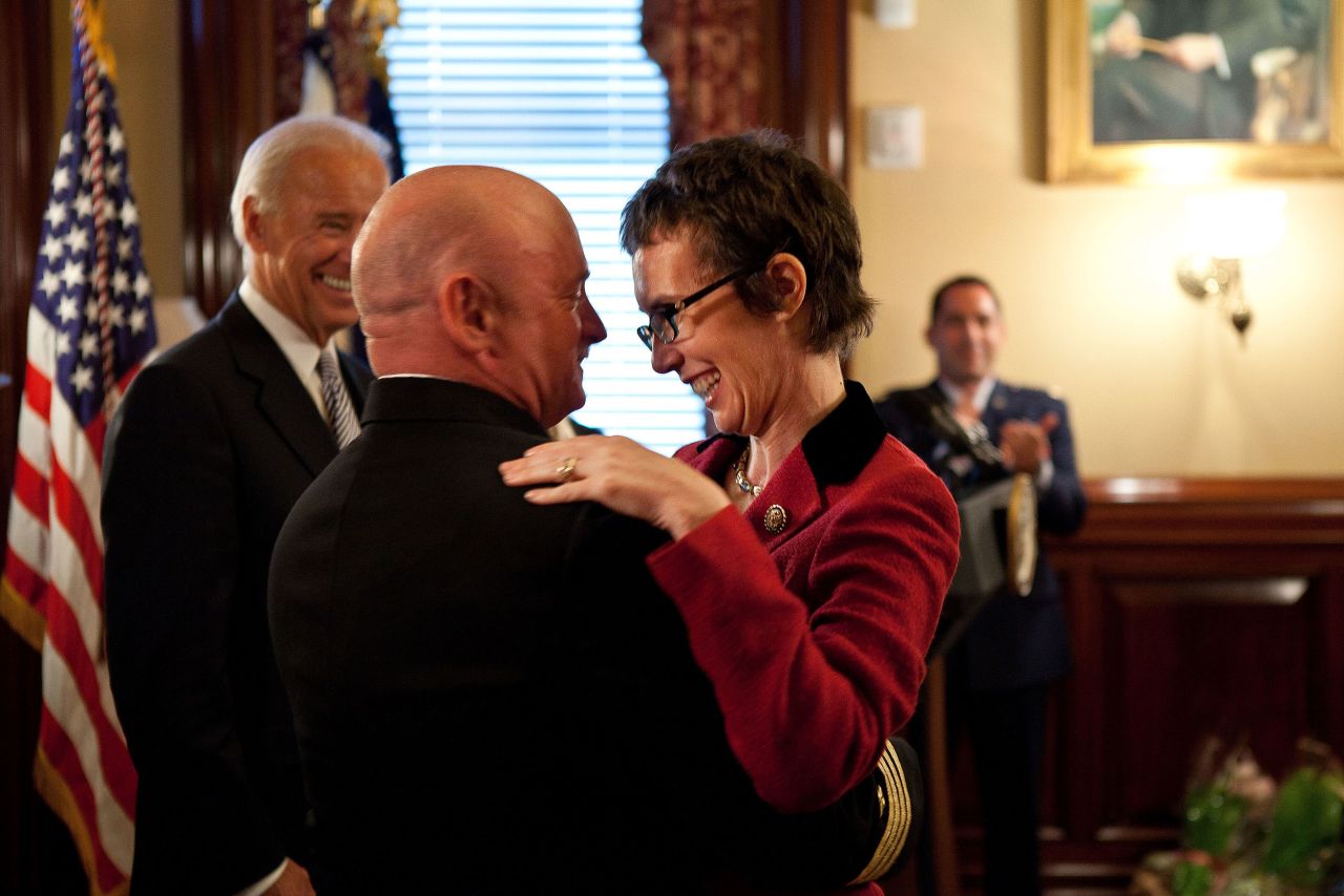 Kelly hugs his wife after he received the Legion of Merit from Vice President Joe Biden, left, during his retirement ceremony in Washington, DC, in October 2011.
