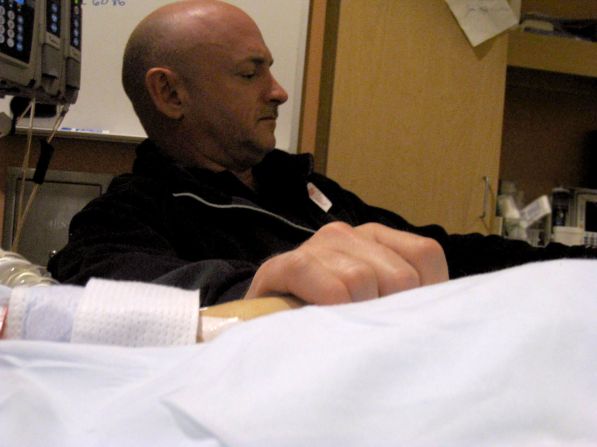 Giffords' husband, Mark Kelly, holds his wife's hand in her hospital room on January 9, 2011.