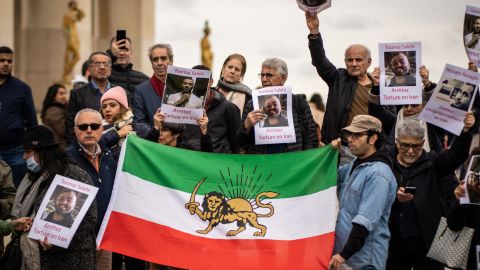 A group of protesters hold an Iranian flag and banners with the portrait of Toomaj Salehi in Paris on November 5, 2022.