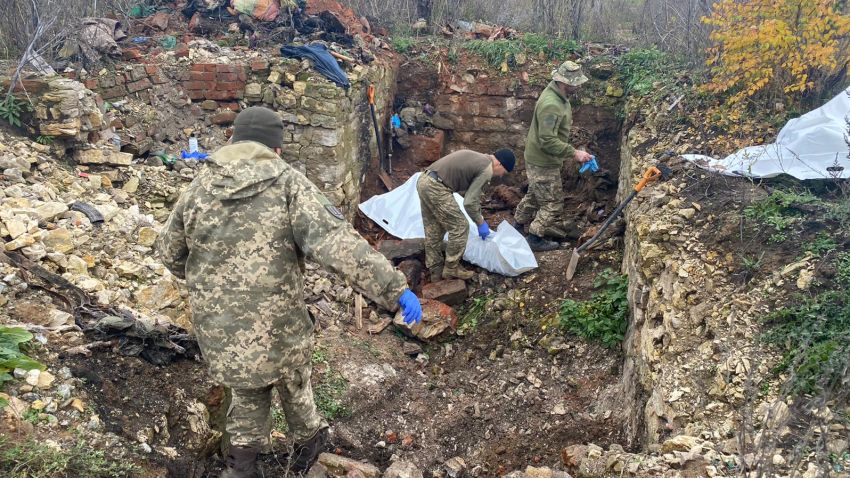 The team sifts through rubble in a collapsed bunker to identify fallen soldiers.