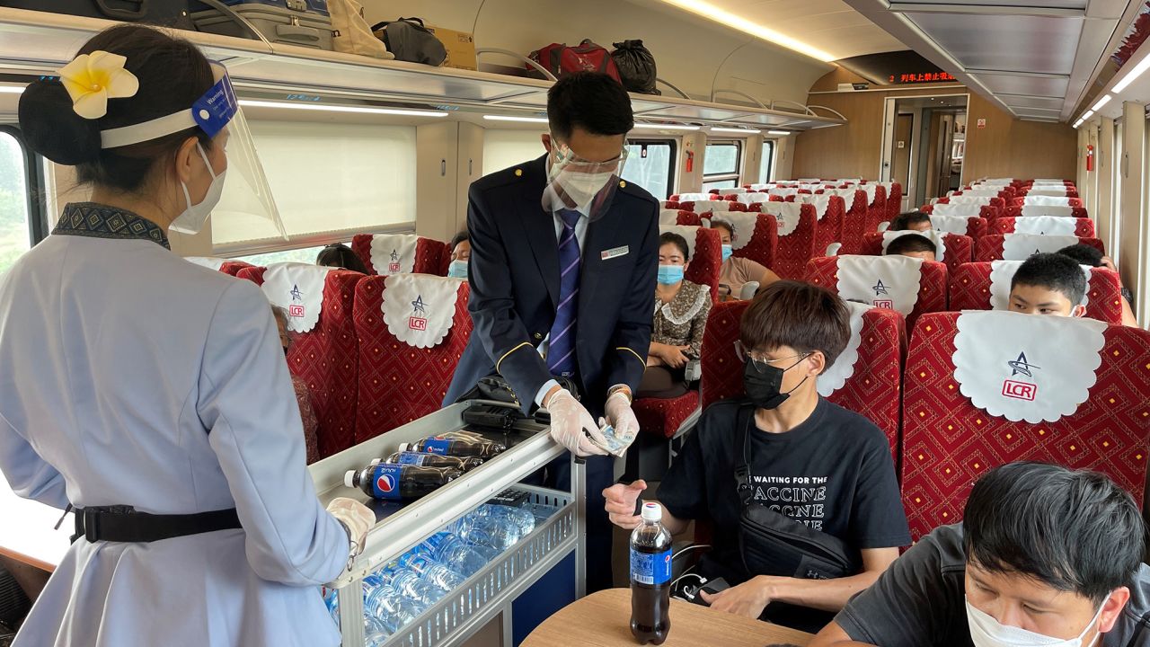 Railway staff push a drink trolley through the new semi-high-speed train. 