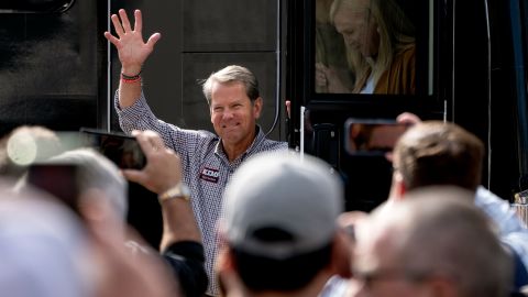 Georgia Republican Gov. Brian Kemp waves as he steps off his tour bus at a campaign rally on November 1, 2022, in Cumming, Georgia. 