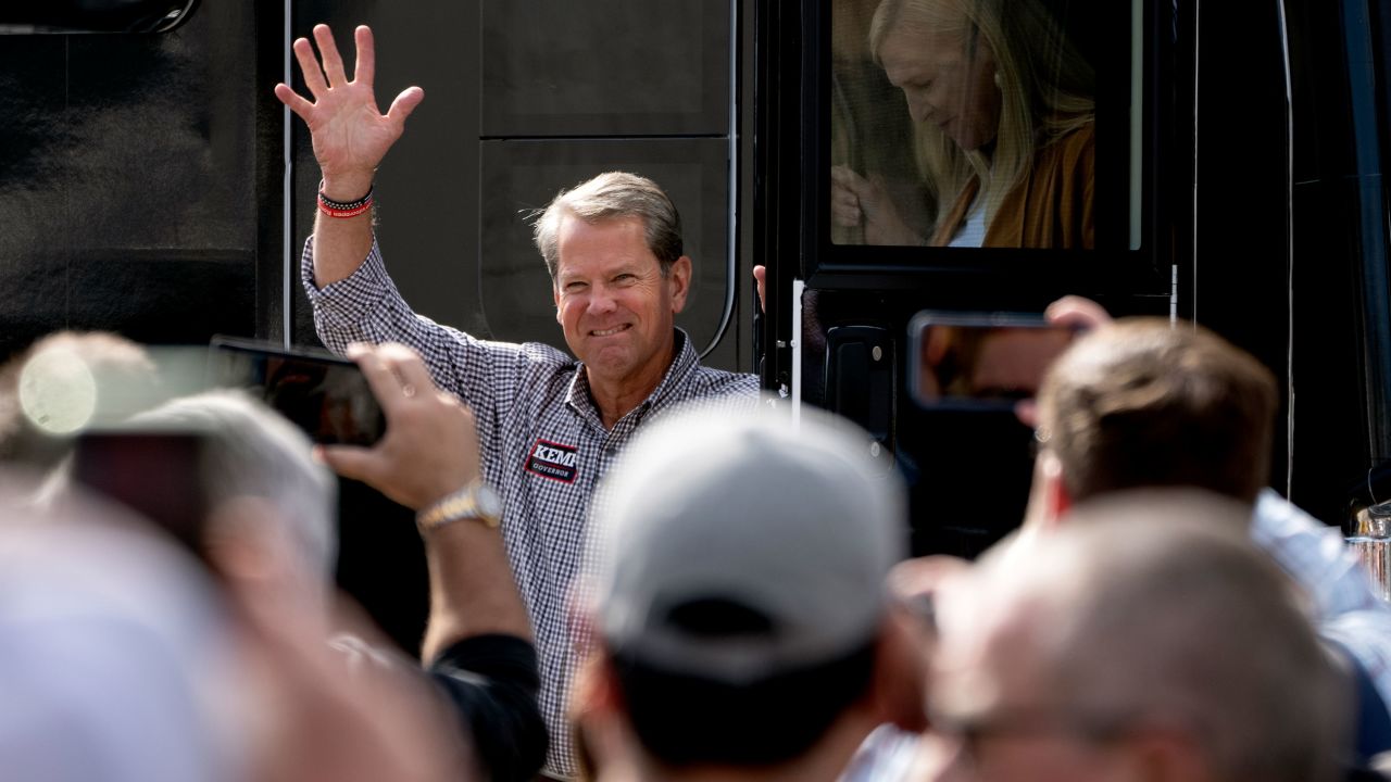 Georgia Republican Gov. Brian Kemp waves as he steps off his tour bus at a campaign rally on November 1, 2022, in Cumming, Georgia. 