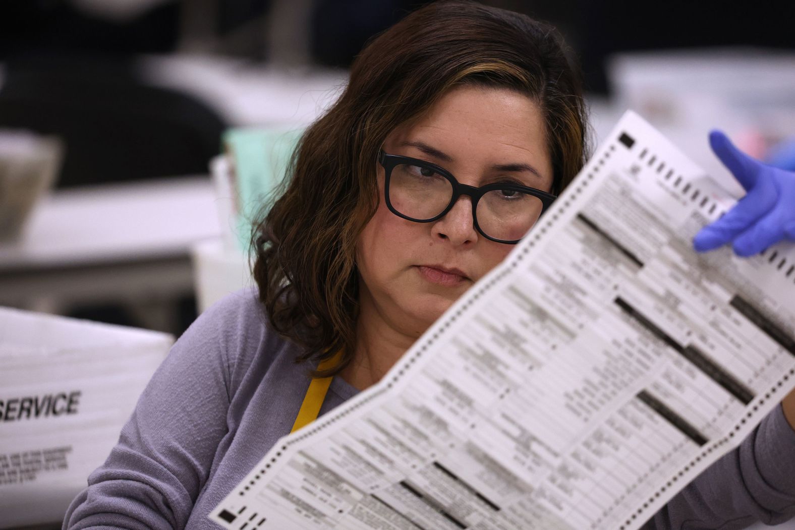 An election worker inspects a mail-in ballot in Phoenix on November 6.