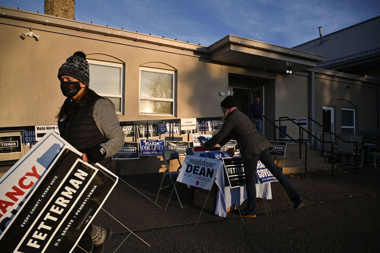 People move campaign signs outside a polling station in Bryn Athyn, Pennsylvania, on Tuesday.