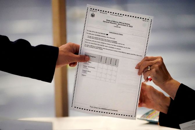 A clerk hands a ballot to a voter in Lewiston, Maine.