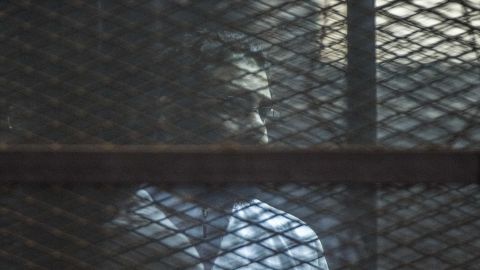 Prominent British-Egyptian activist Alaa Abd el-Fattah stands in a cage during a sentencing hearing for 21 people over an unauthorized 2013 street protest in a courtroom in Cairo, Egypt in 2015.