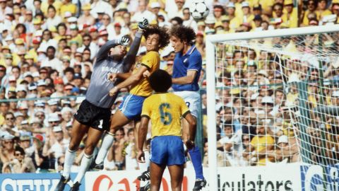 Italian forward Francesco Graziani tries to reach the ball with his head, but Brazilian goalkeeper Valdir Peres saves the ball with the help of his defender Oscar.