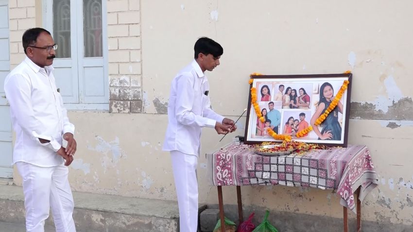 A grieving relative offers his respects to the 12 members of the Bodha family who died.