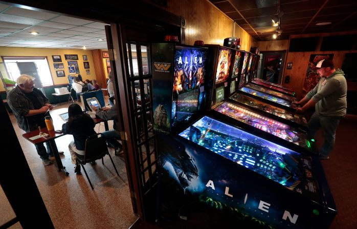 Matt Koenen plays pinball at West County Lanes in Ellisville, Missouri, as voters cast their ballots in the bowling alley's party room on Election Day.