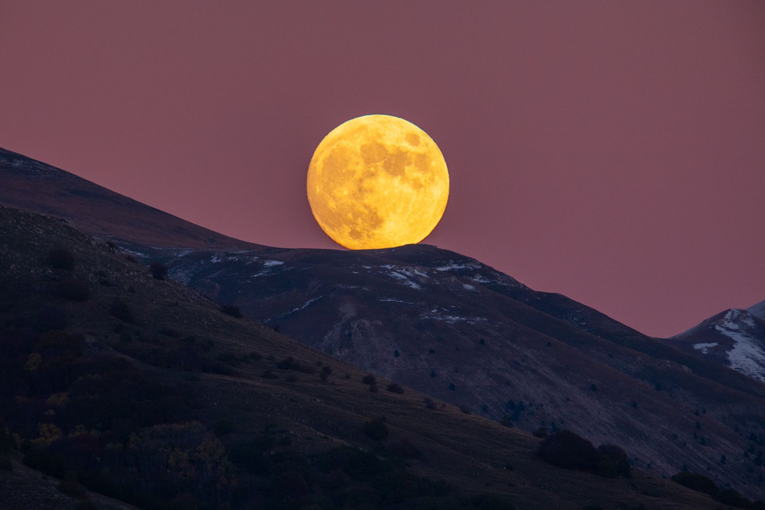 The beaver moon is seen rising behind Gran Sasso d'Italia peaks from L'Aquila, Italy, on November 7.