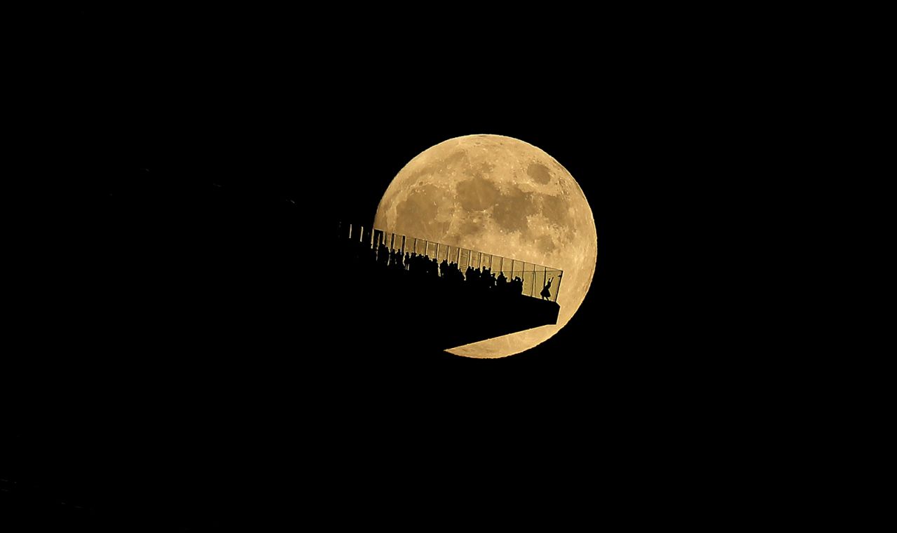 The full moon rises behind the Edge NYC observation deck ahead of a lunar eclipse in New York City on November 7, as seen from Hoboken, New Jersey. 