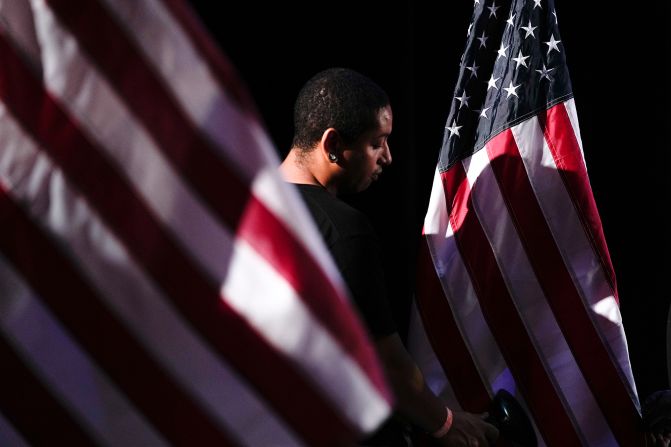 A worker uses a steamer to get the wrinkles out of an American flag before the start of at an election night watch party in Los Angeles.