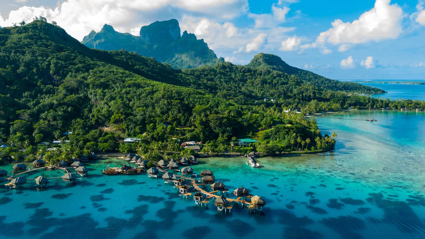 Bora Bora aerial drone video of travel vacation paradise with overwater bungalows luxury resort, coral reef lagoon ocean beach. Mount Otemanu, Bora Bora, French Polynesia, Tahiti, South Pacific Ocean