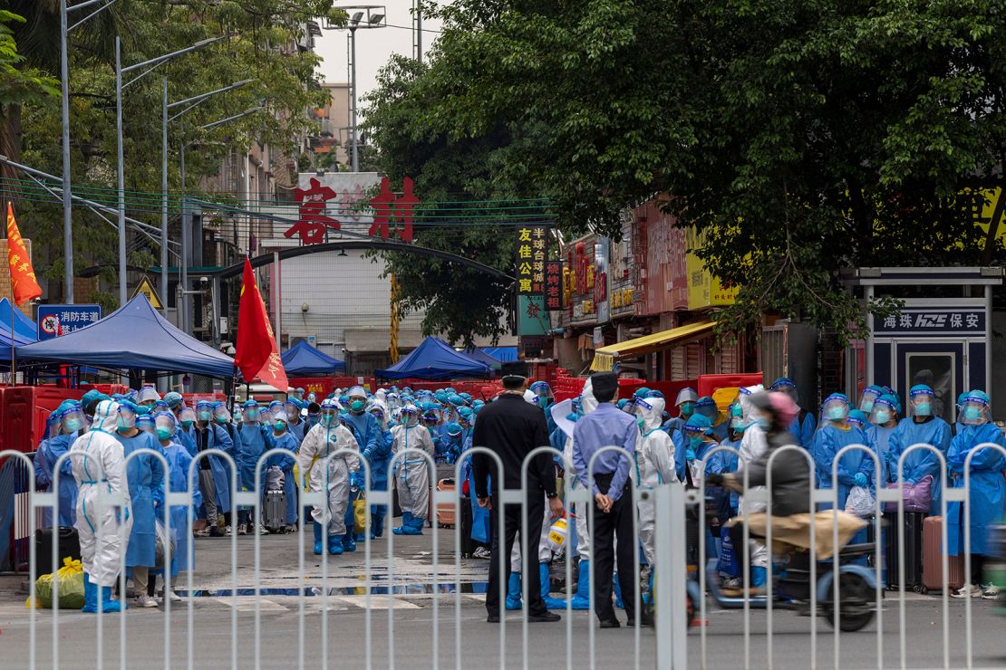 Workers dressed in white suits prepare to transfer residents, wearing blue protective suits, at a village in Guangzhou after a Covid outbreak on November 5.
