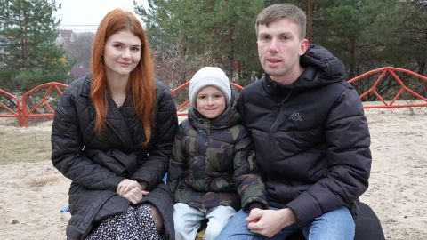 Maria Bespalaya, Ilya Kostushevich และ Vladimir Bespalov นั่งด้วยกันบนม้านั่งในสนามเด็กเล่นใน Kyiv