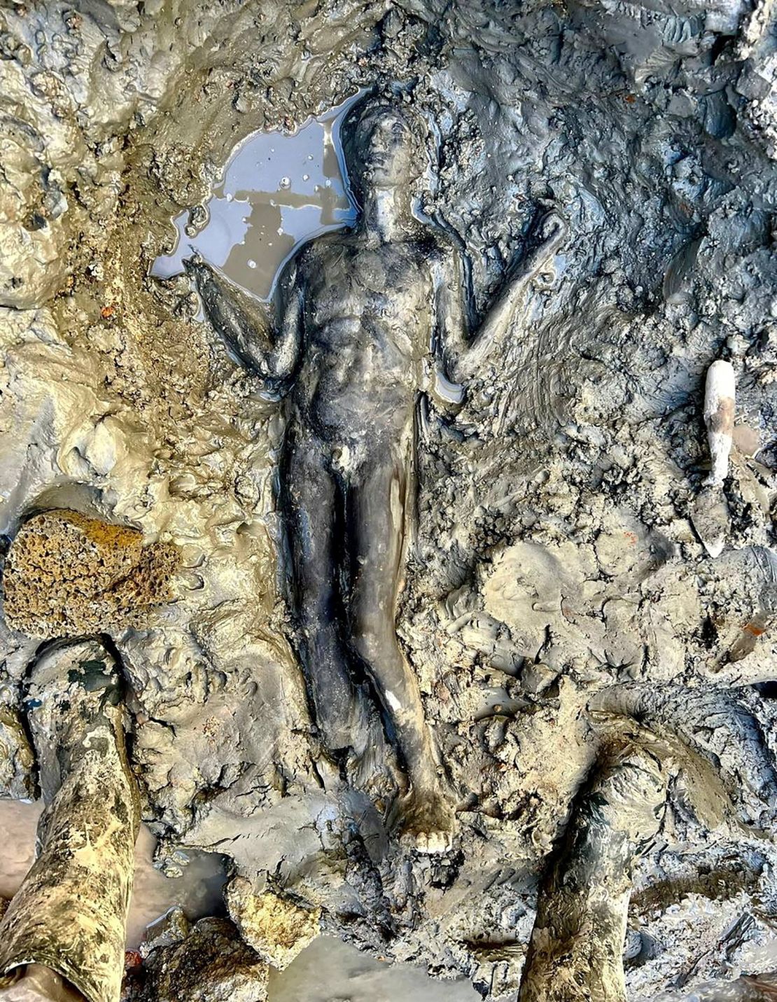 A newly discovered 2,300-year-old bronze statue lies on the ground in San Casciano dei Bagni, Italy.