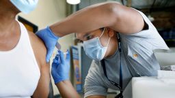  Jeremy Oyague, right, a registered nurse with The Los Angeles Department of Public Health, administers a COVID booster at a vaccination clinic in Los Angeles. (Christina House / Los Angeles Times via Getty Images)