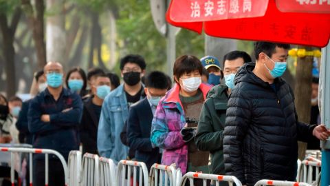 11 月 10 日、中国の北京で Covid-19 検査の列に並ぶマスク姿の人々。