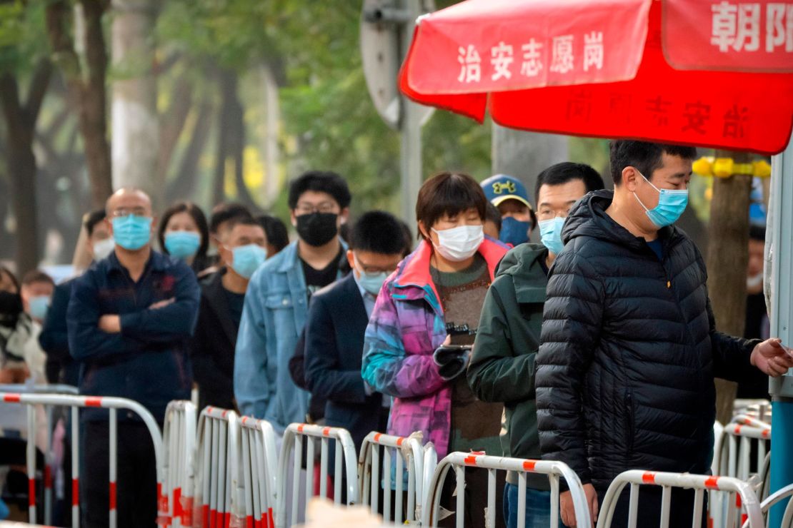 People in face masks wait in line for Covid-19 tests in Beijing, China, on November 10.