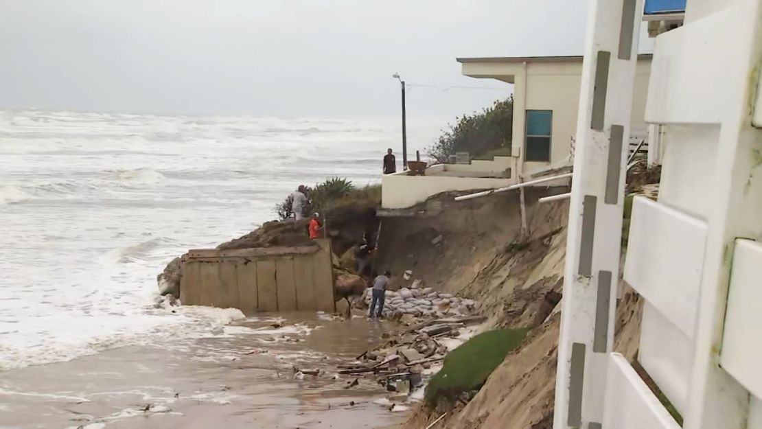 A Wilbur-by-the-Sea beachside home was left on the edge of a sandy cliff Wednesday after rough surf and storm surge caused by Tropical Storm Nicole washed away about 20 feet of sand.
