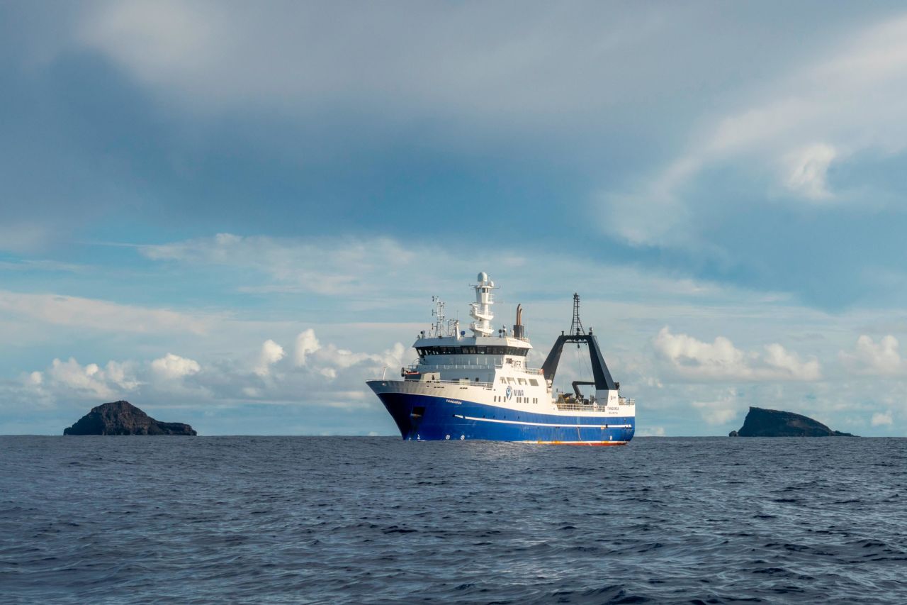 The RV Tangaroa, NIWA's research vessel, set sail in April 2022 to map the seafloor. Here, it is flanked by Hunga Ha'apai on the left, and Hunga Tonga on the right — the space in between is where the volcano caldera used to be.
