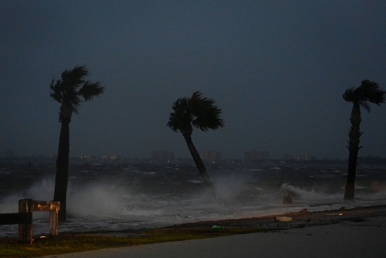 Palm trees are pounded by high tide and winds in Jensen Beach.