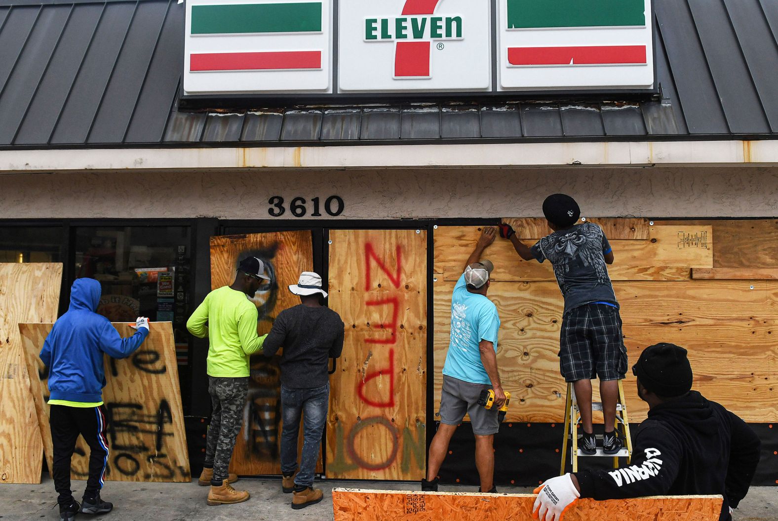 Workers board up a store with plywood in Daytona Beach Shores on Wednesday.