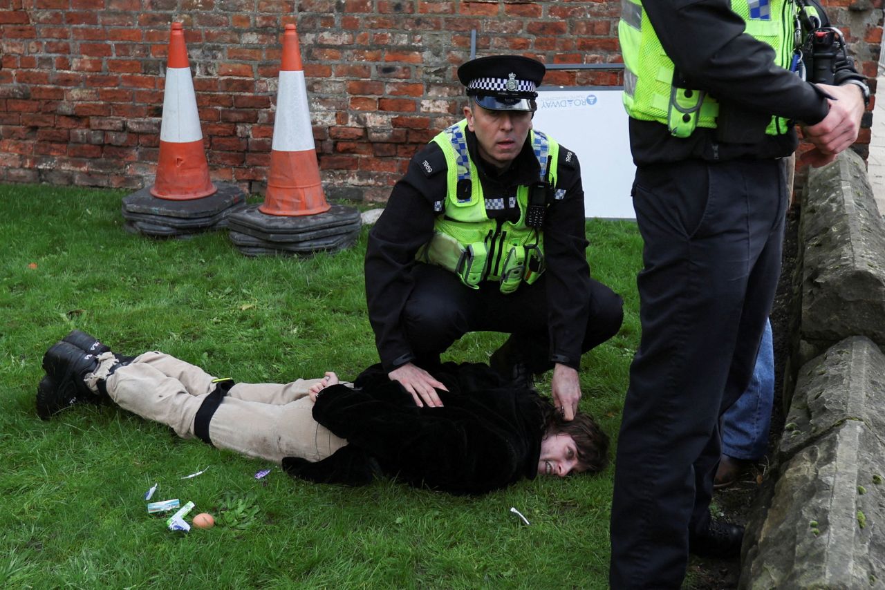 A police officer restrains a protester who was accused of <a href="https://www.cnn.com/videos/world/2022/11/09/eggs-thrown-king-charles-man-arrested-york-cprog-orig-llr.cnn" target="_blank">throwing eggs at Britain's King Charles III</a> in York, England, on Wednesday, November 9.