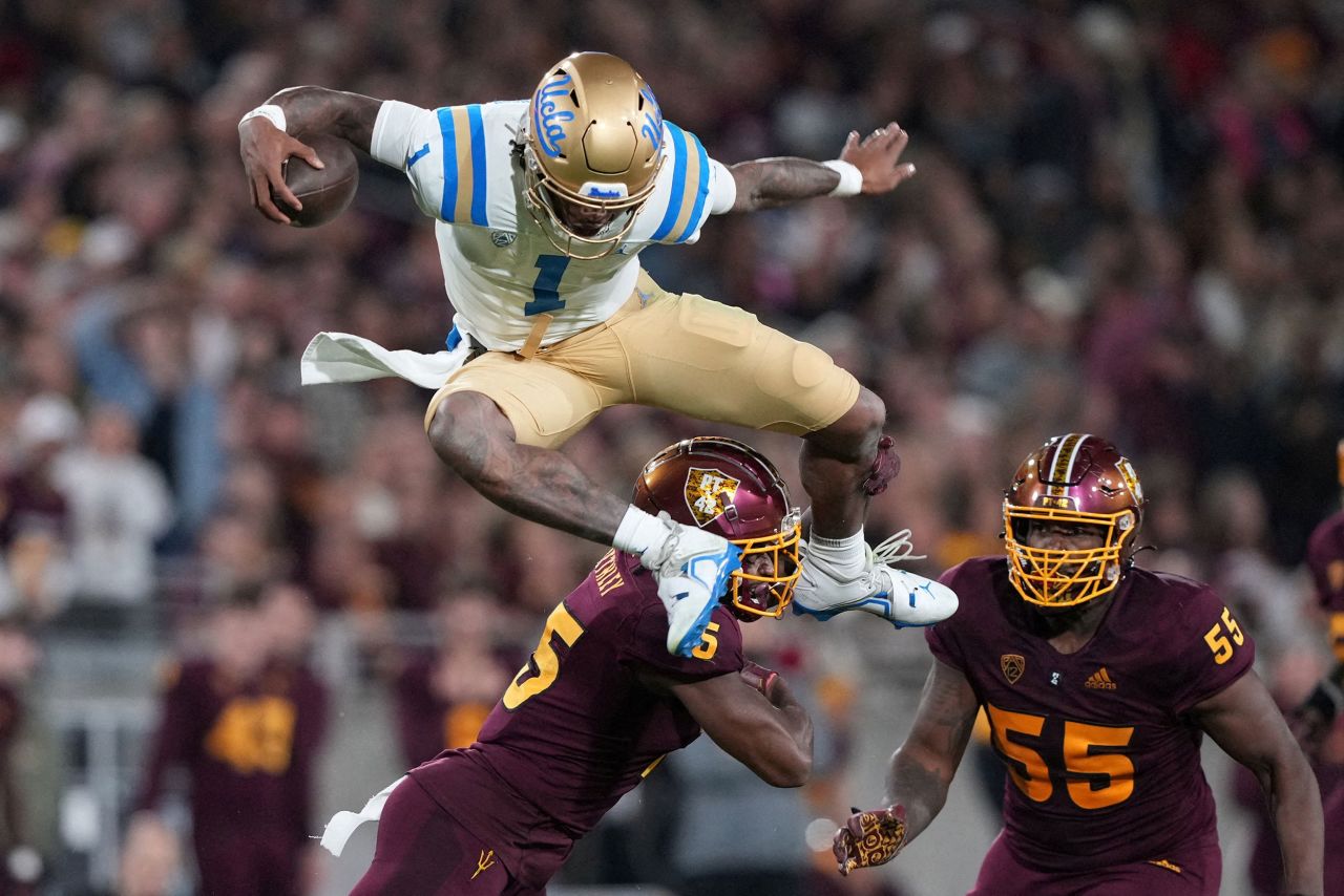 UCLA quarterback Dorian Thompson-Robinson hurdles an Arizona State defender during a college football game in Tempe, Arizona, on Saturday, November 5.