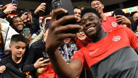 Canada midfielder Alphonso Davies -- here signing autographs and taking photos with fans -- helped lead his country to the World Cup.