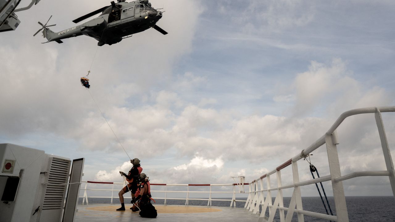 A migrant in need of urgent medical care is winched up on a stretcher by a helicopter of the French Army from the Ocean Viking rescue ship on November 10, 2022 in the Tyrrhenian Sea between Italy and Corsica island.