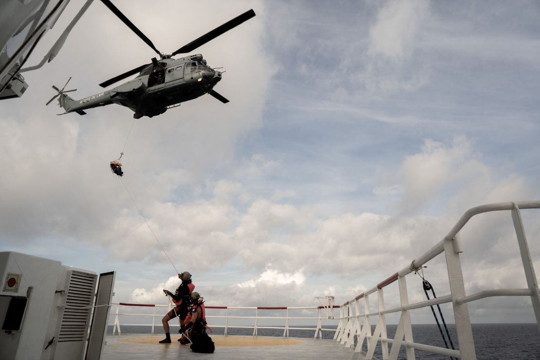 A migrant in need of urgent medical care is winched up on a stretcher by a helicopter of the French Army from the Ocean Viking rescue ship on November 10, 2022 in the Tyrrhenian Sea between Italy and Corsica island. 