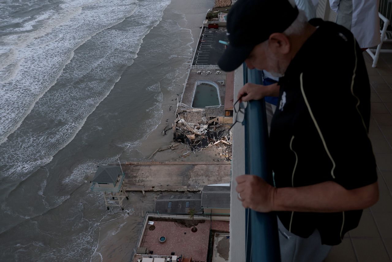 Reda Daabies looks at a breached seawall from the 18th floor of his condo in Daytona Beach on Thursday.
