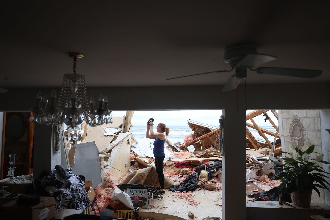 Lisa Lavigna takes pictures of her mother's home in Daytona Beach on Thursday.