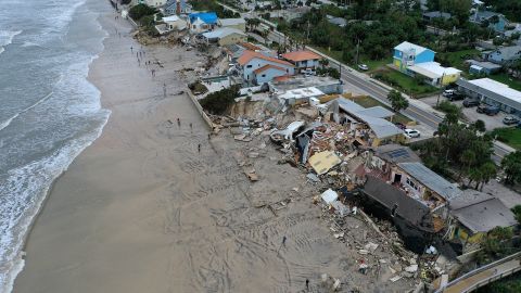 In this aerial view, homes are partially toppled onto the beach after Hurricane Nicole made landfall on November 10, 2022 in Daytona Beach, Florida. 