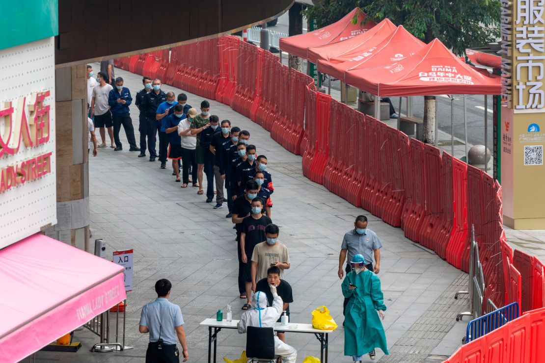 People line up last week for Covid-19 screening in a market enclosed by a temporary wall in Guangzhou, China.  