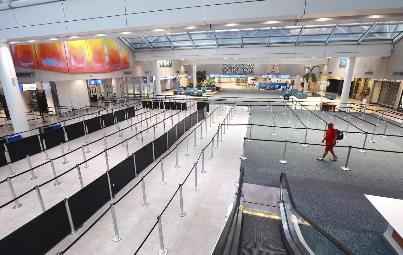 A lone passenger walks through the A terminal at Orlando International Airport on Thursday. The airport ceased all commercial operations as Nicole hit Florida.