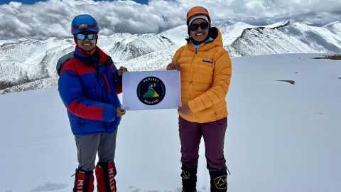 Malavath y Manyapu sostienen su logotipo del Proyecto Shakthi en la cumbre.