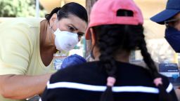 A medical worker collects a swab sample from a resident for a COVID-19 test in Los Angeles, California, the United States, on August 5, 2022. 