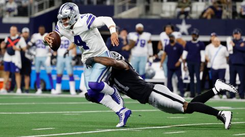 Dak Prescott of the Dallas Cowboys is tackled by Yannick Ngakoue of the Las Vegas Raiders during the fourth quarter of the Las Vegas Raiders and Dallas Cowboys game on November 25, 2021.