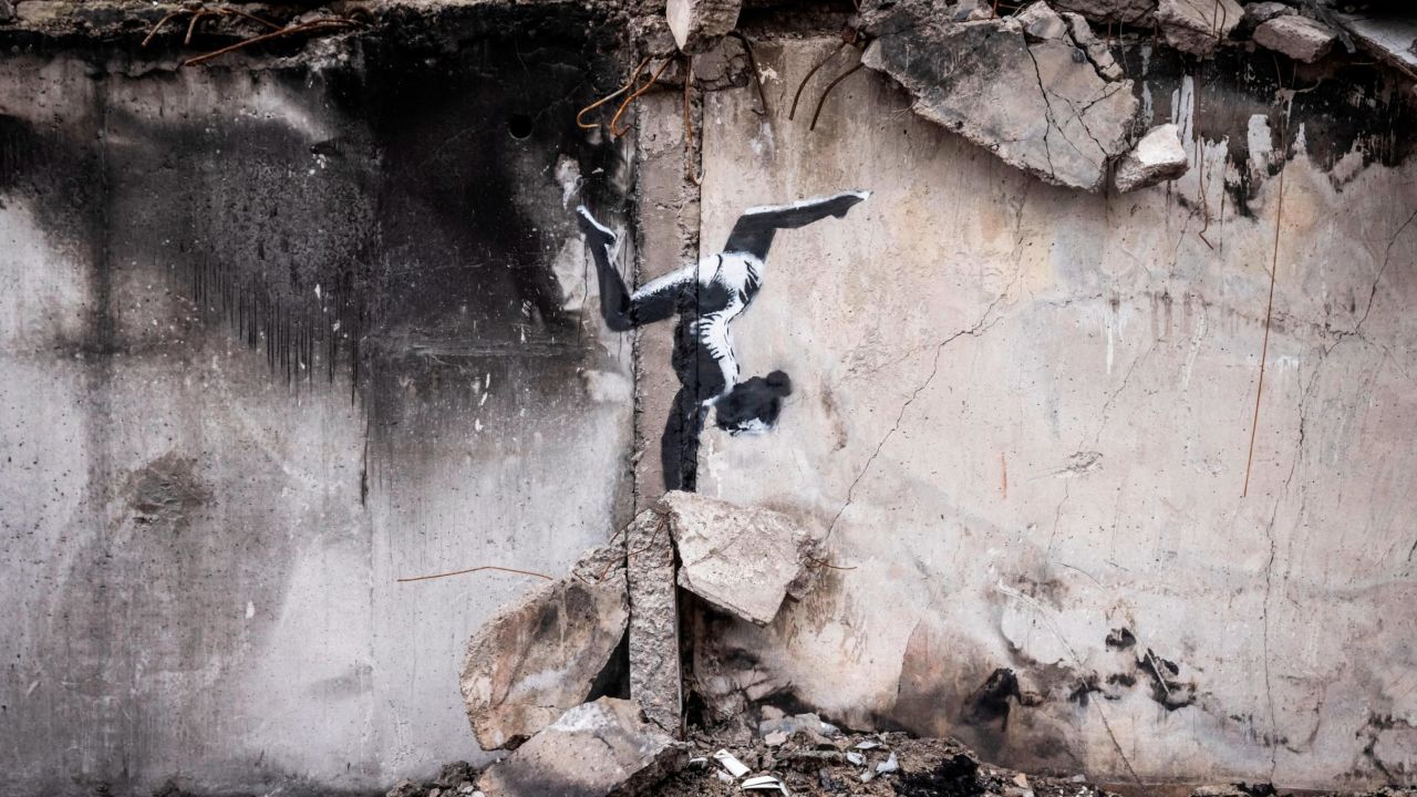 The artwork shows a female gymnast balancing on a pile of rubble on the side of a building damaged by Russian strikes in Borodianka. 